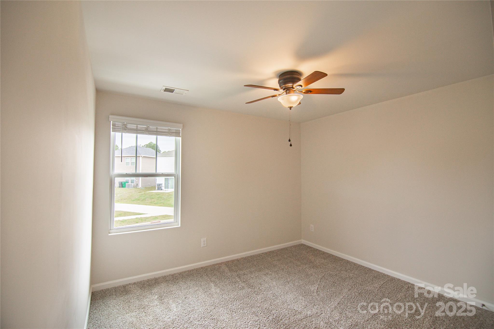 1148 Harland Street, Unit 52 Charlotte, NC 28216 - Photo 16 of 26 an empty room with chandelier fan and windows