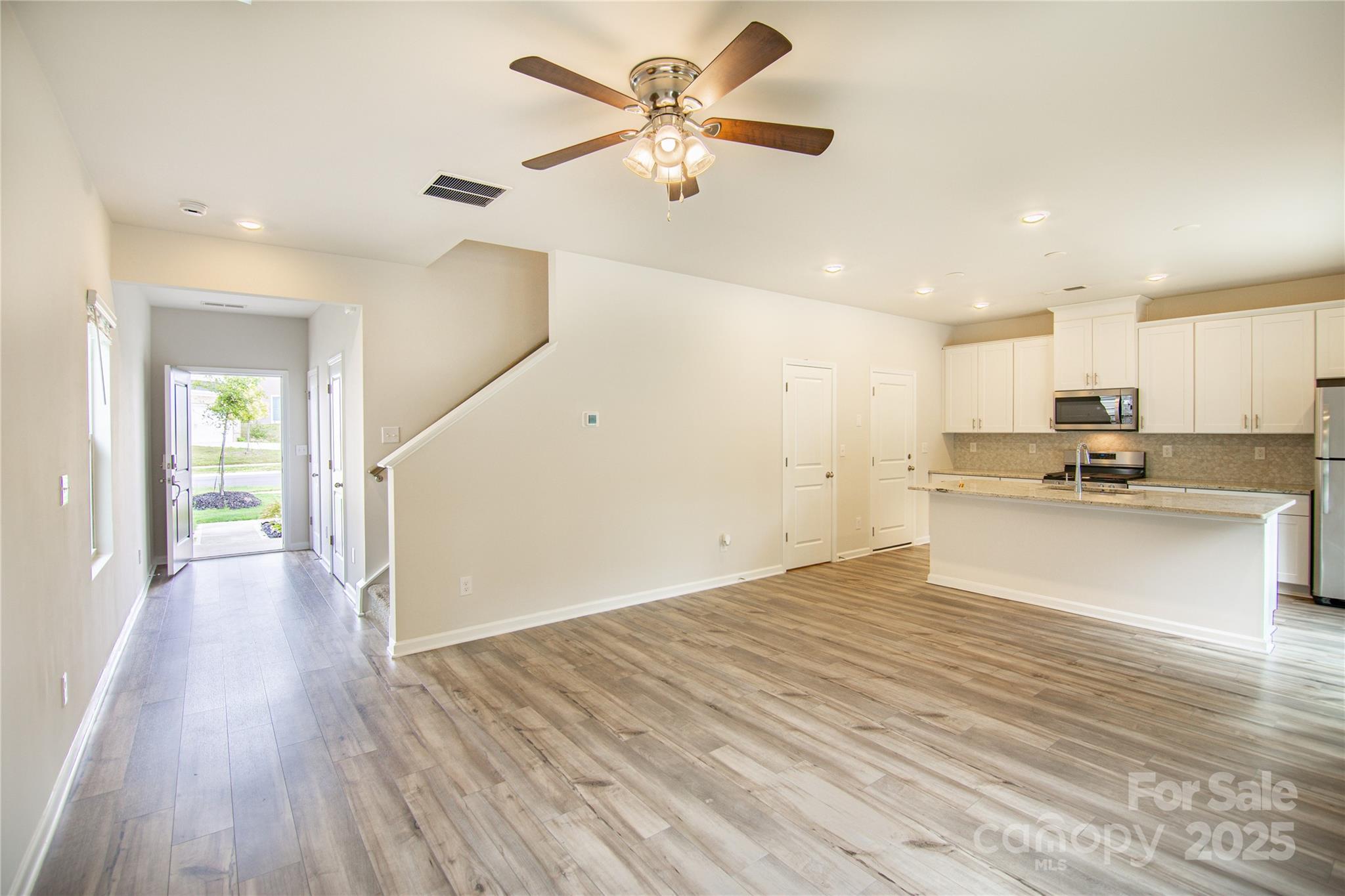 1148 Harland Street, Unit 52 Charlotte, NC 28216 - Photo 4 of 26 a view of an empty room and kitchen with wooden floor