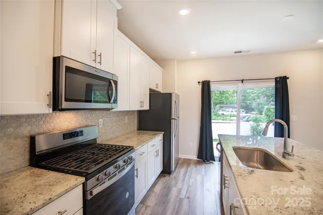a kitchen that has a sink and a stove top oven