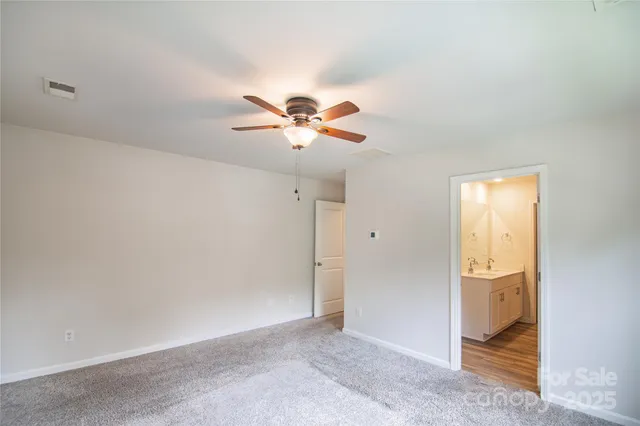 an empty room with closet and ceiling fan