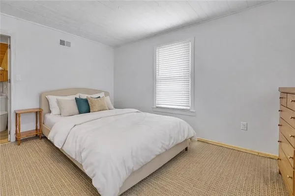 a large bed sitting in a bedroom next to a window