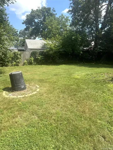 a view of a green field with wooden fence