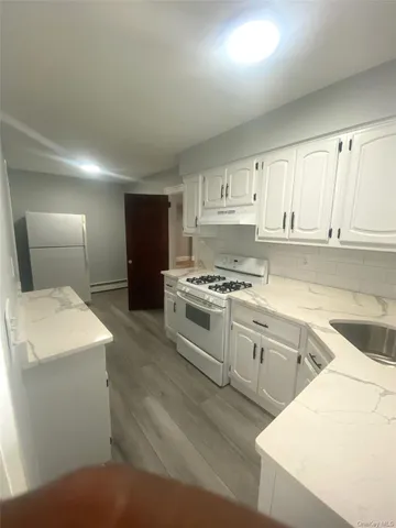 a kitchen with a white cabinets and white appliances