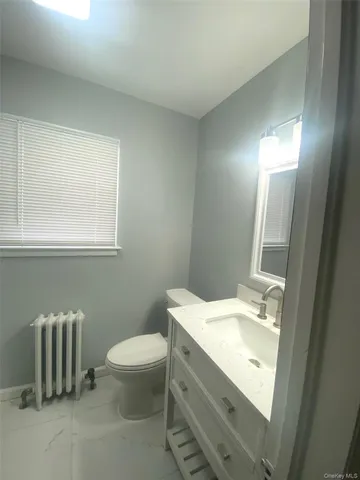 a bathroom with a sink toilet and a mirror