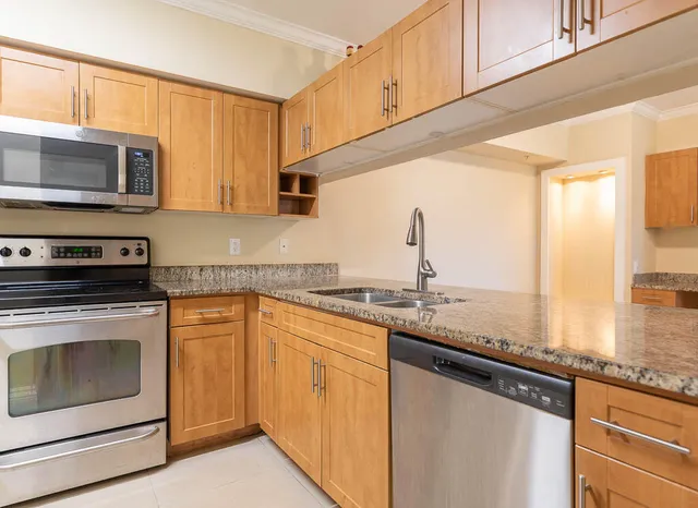a kitchen with granite countertop a stove and a sink
