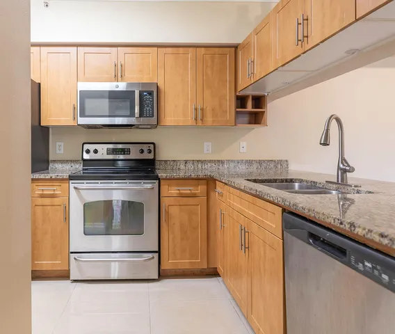 a bathroom with a granite countertop sink and washing machine