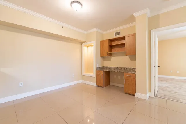 a kitchen with granite countertop a refrigerator and cabinets