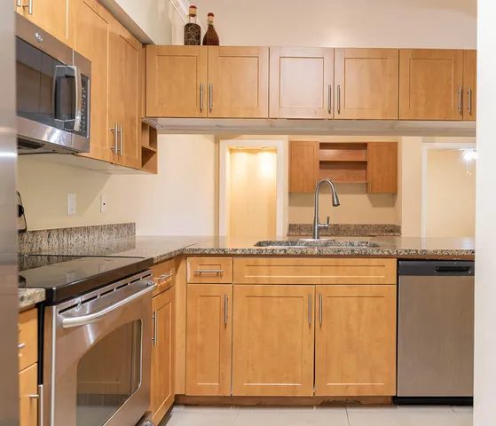 a kitchen with stainless steel appliances granite countertop white cabinets and a granite counter tops