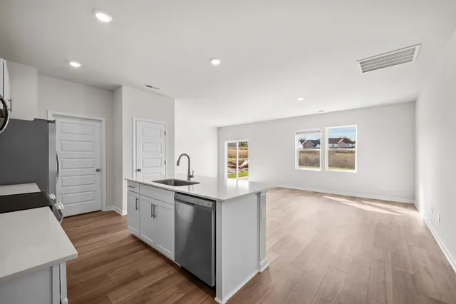 a kitchen with granite countertop a sink and a stove top oven