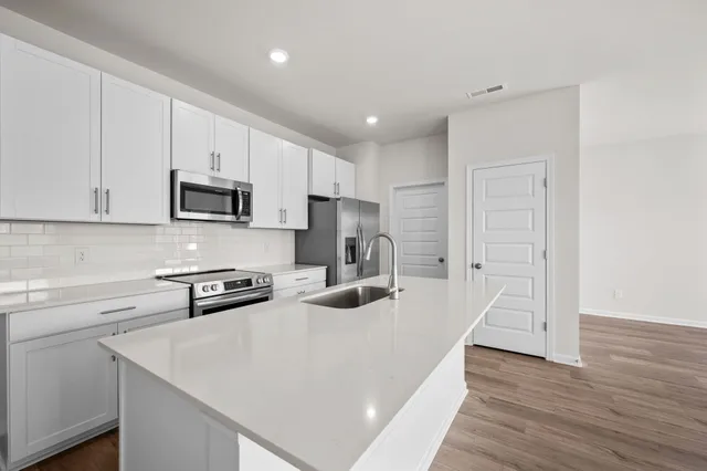 a kitchen with kitchen island a white counter top space and cabinets