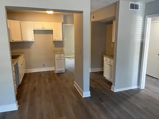 a view of a kitchen cabinets a stove and wooden floor