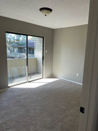 an empty room with sliding glass door and shower
