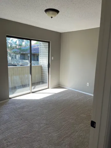 an empty room with sliding glass door and shower