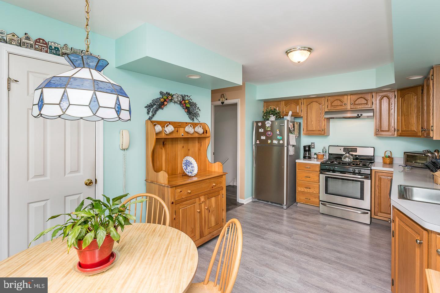 1941 Oak Leaf Lane Holmes, PA 19043 - Photo 13 of 44 a kitchen with stainless steel appliances granite countertop a refrigerator a stove a sink dishwasher and a dining table with wooden floor
