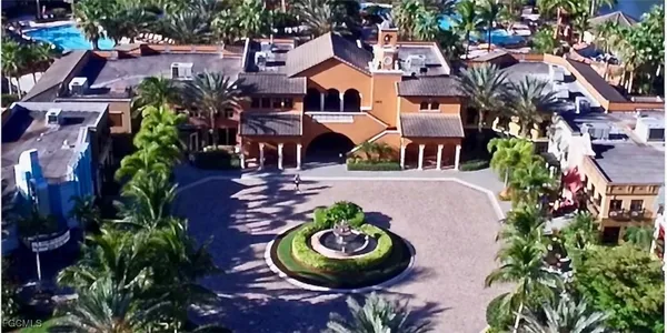 a view of a dining room with furniture a chandelier and large windows