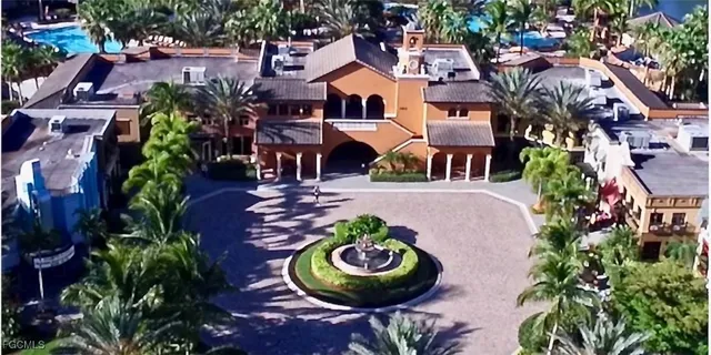 a view of a dining room with furniture a chandelier and large windows