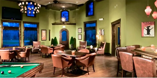 a view of a swimming pool with a table and chairs under palm trees