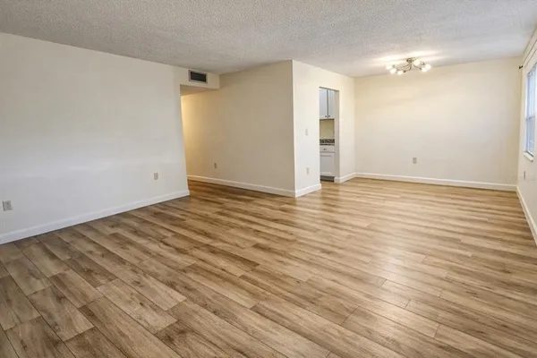 a view of an empty room with wooden floor