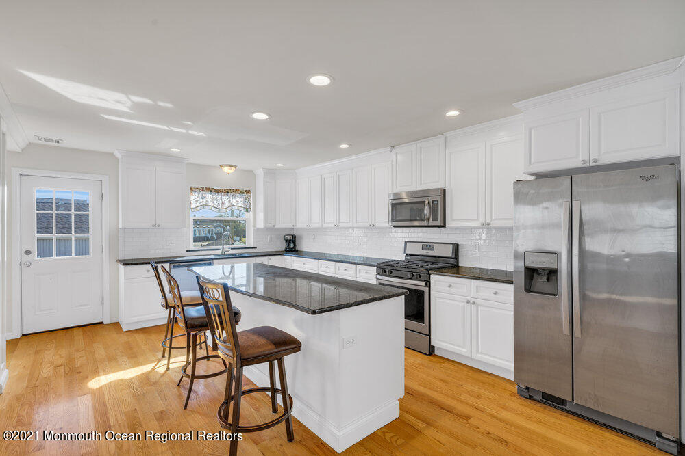 32 Niblick Street Point Pleasant Beach, NJ 08742 - Photo 12 of 38 a kitchen with a table chairs refrigerator and cabinets