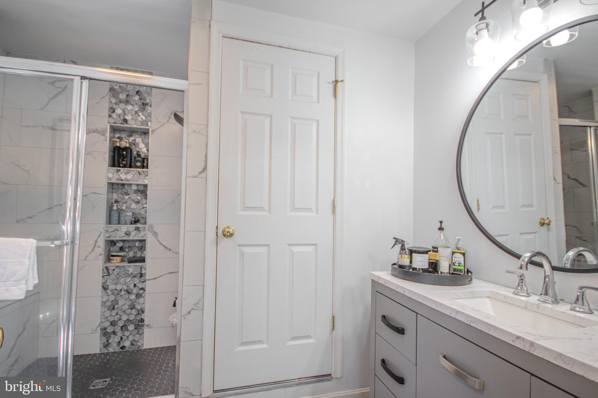 1519 Anchors Way Salisbury, MD 21801 - Photo 22 of 49 a bathroom with a granite countertop sink a mirror and a shower