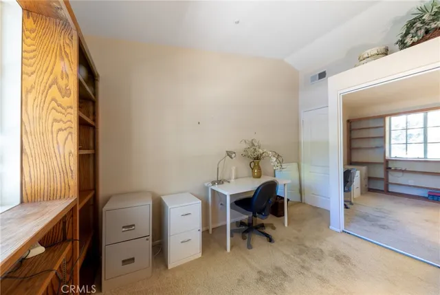 a view of a workspace with furniture and a window