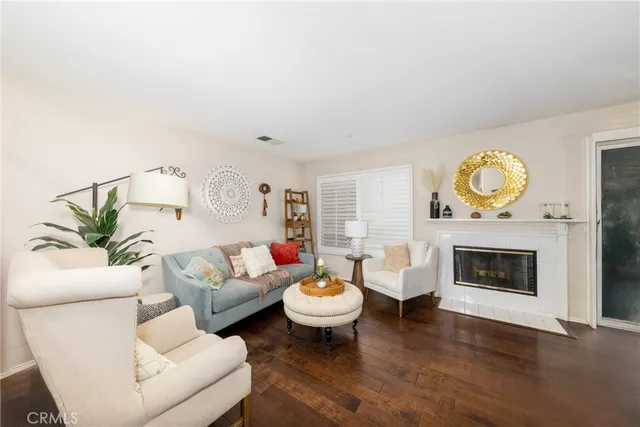 a living room with furniture a fireplace and a potted plant