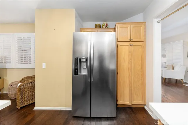 a view of a kitchen with wooden floor and a refrigerator