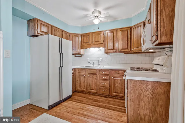 a kitchen with stainless steel appliances granite countertop a refrigerator a stove and a sink with cabinets