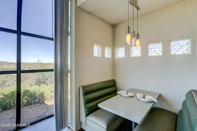 a view of a workspace with furniture and a window
