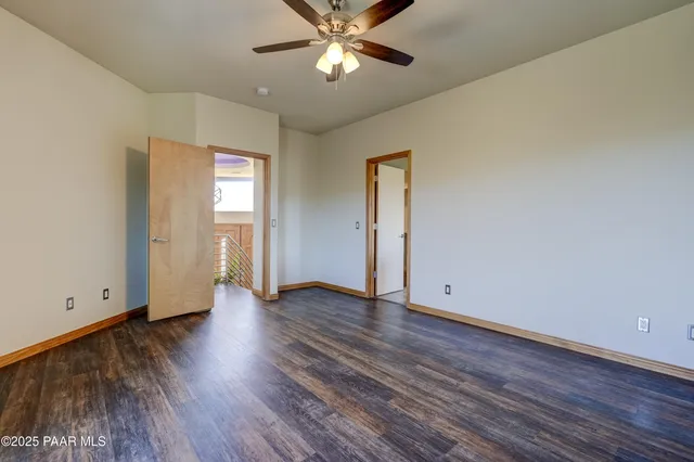 an empty room with wooden floor a ceiling fan and closet