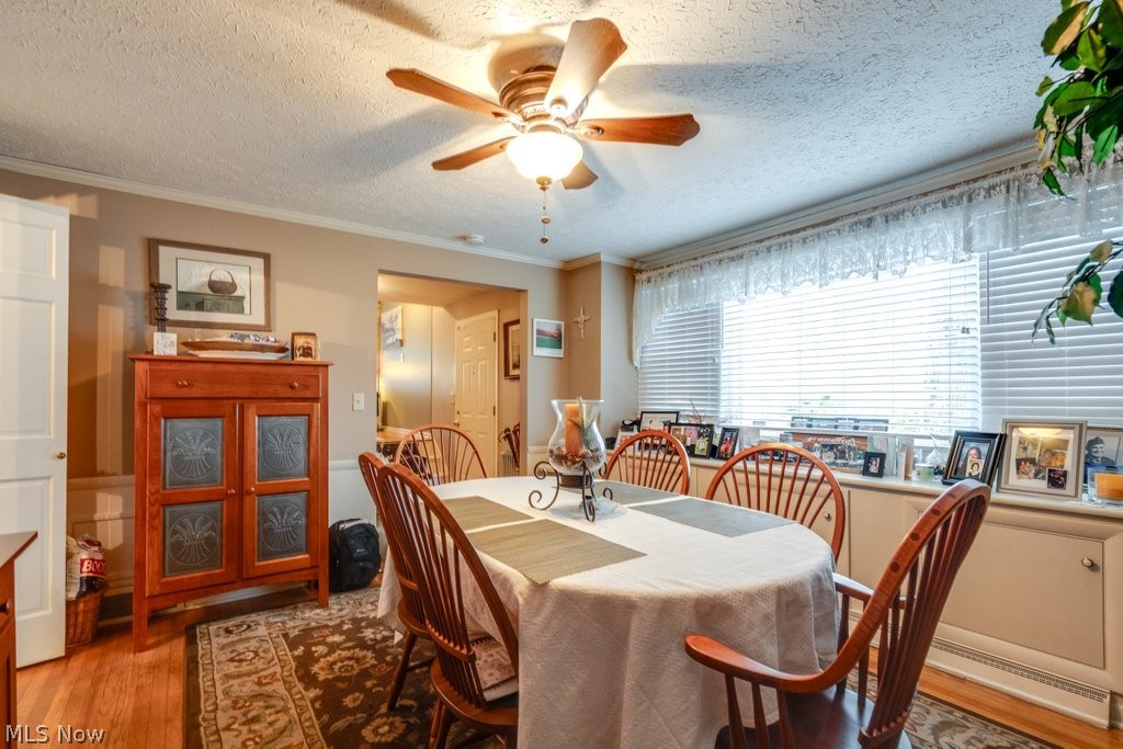 5981 Wiclif Road Northeast Canton, OH 44721 - Photo 7 of 50 Dining area with wood finished floors, a textured ceiling, a ceiling fan, and ornamental molding