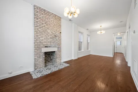a view of a livingroom with a fireplace wooden floor and a fireplace