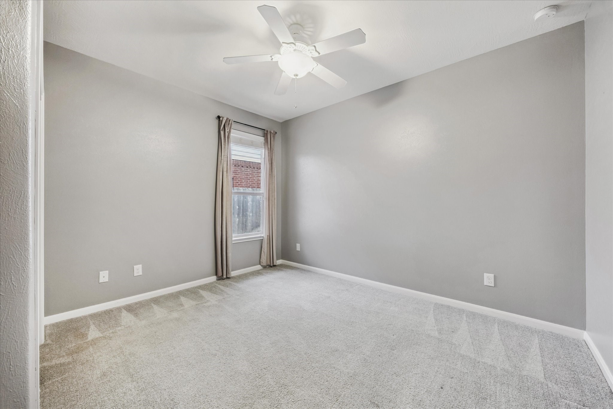 8506 Sweetstone Field Court Cypress, TX 77433 - Photo 23 of 33 an empty room with a ceiling fan and a window