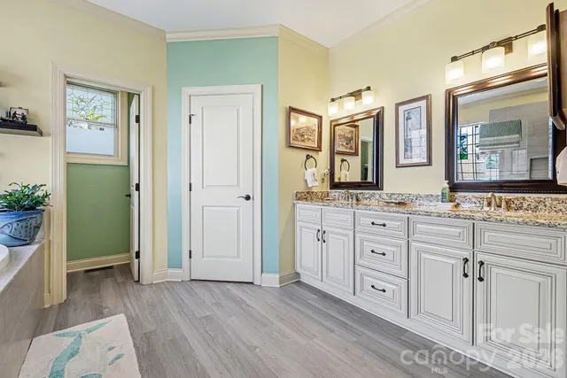 a bathroom with a tub a sink a window and a shower