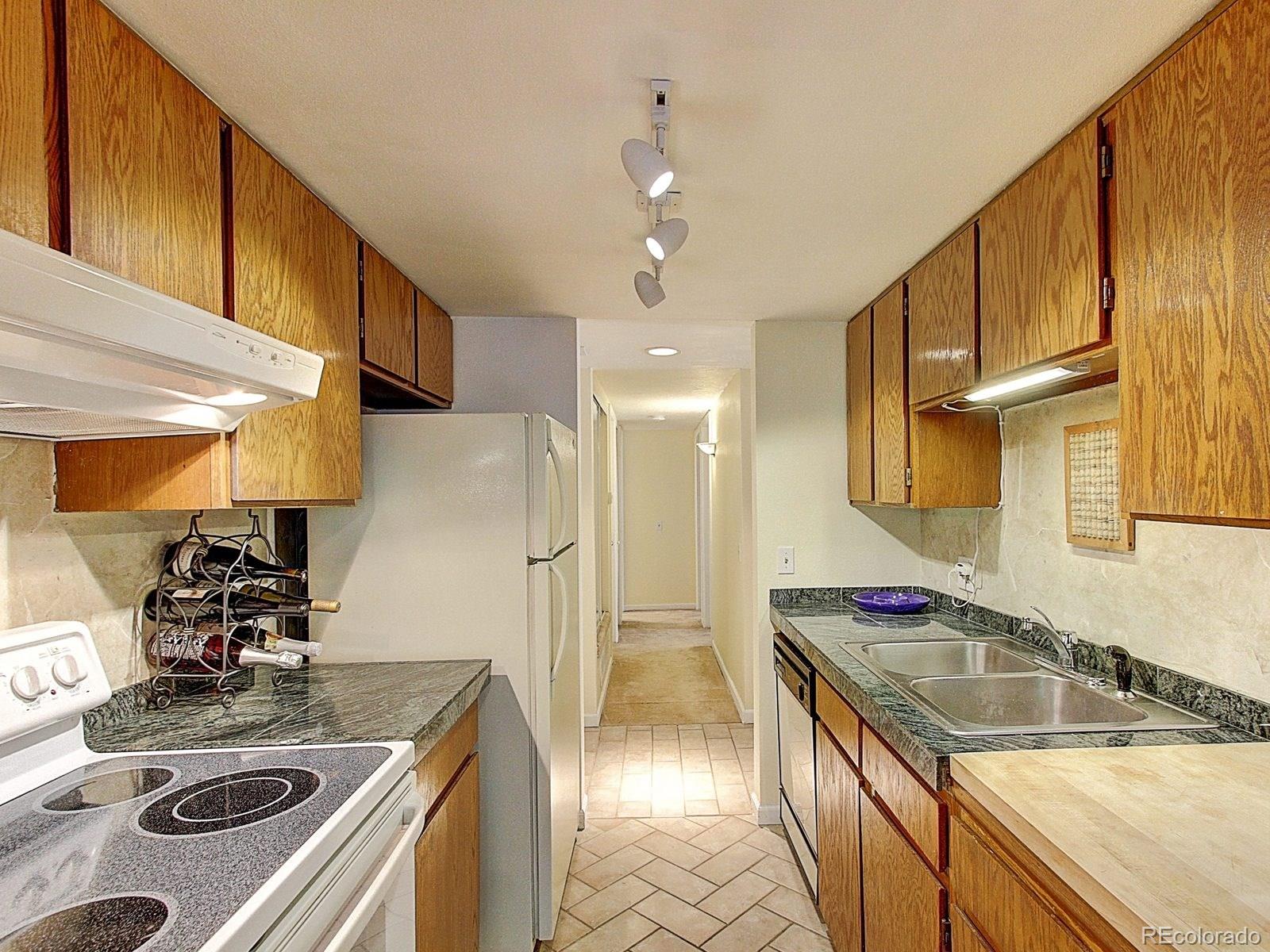 6410 South Dayton Street, Unit I08 Englewood, CO 80111 - Photo 12 of 32 a kitchen with stainless steel appliances granite countertop a sink stove and refrigerator