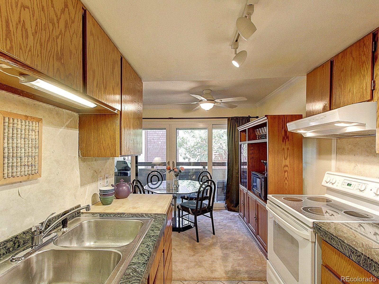 6410 South Dayton Street, Unit I08 Englewood, CO 80111 - Photo 14 of 32 a kitchen with stove a sink and cabinets