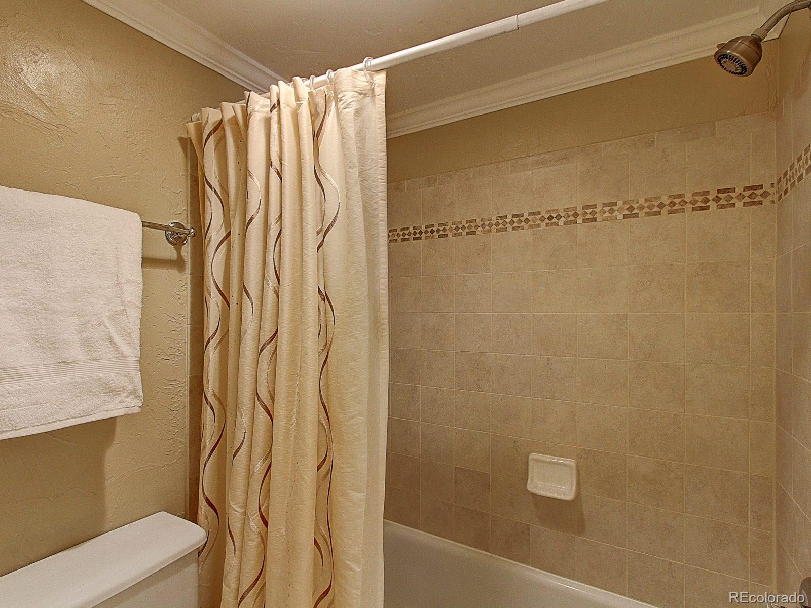 6410 South Dayton Street, Unit I08 Englewood, CO 80111 - Photo 22 of 32 a bathroom with a shower and a toilet
