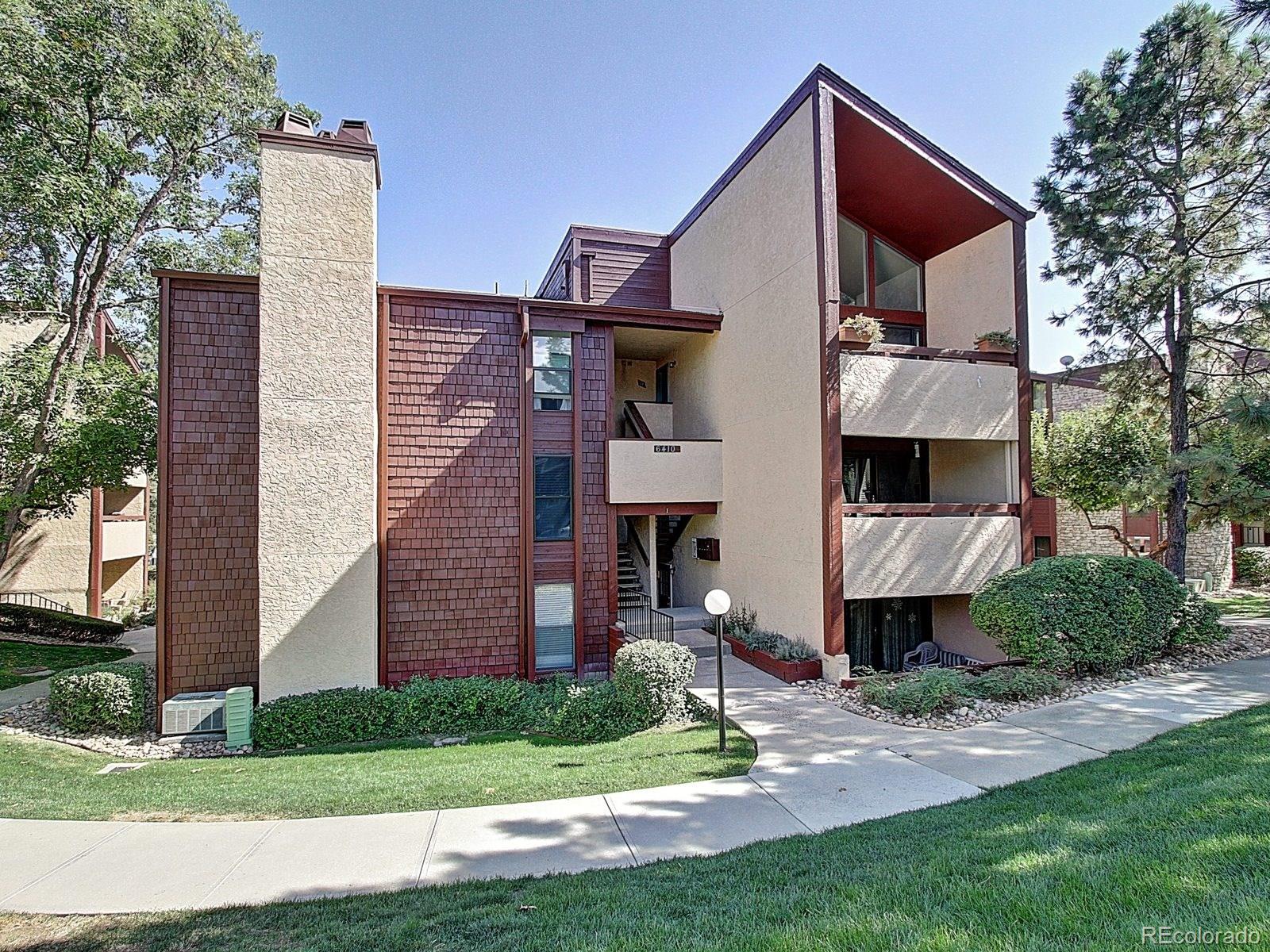 6410 South Dayton Street, Unit I08 Englewood, CO 80111 - Photo 30 of 32 a front view of a house with a yard and garage