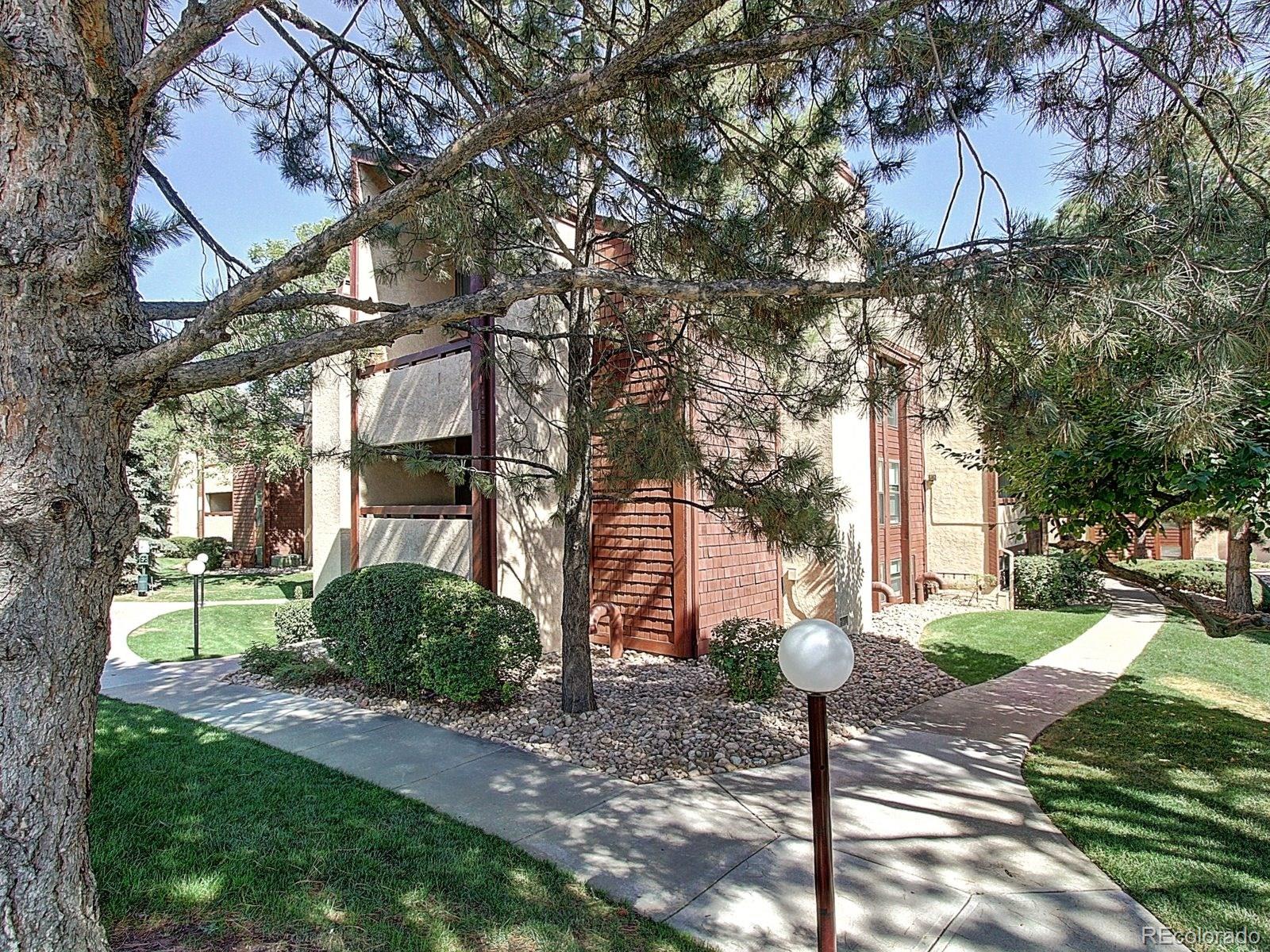 6410 South Dayton Street, Unit I08 Englewood, CO 80111 - Photo 31 of 32 a view of a white house next to a yard and a tree