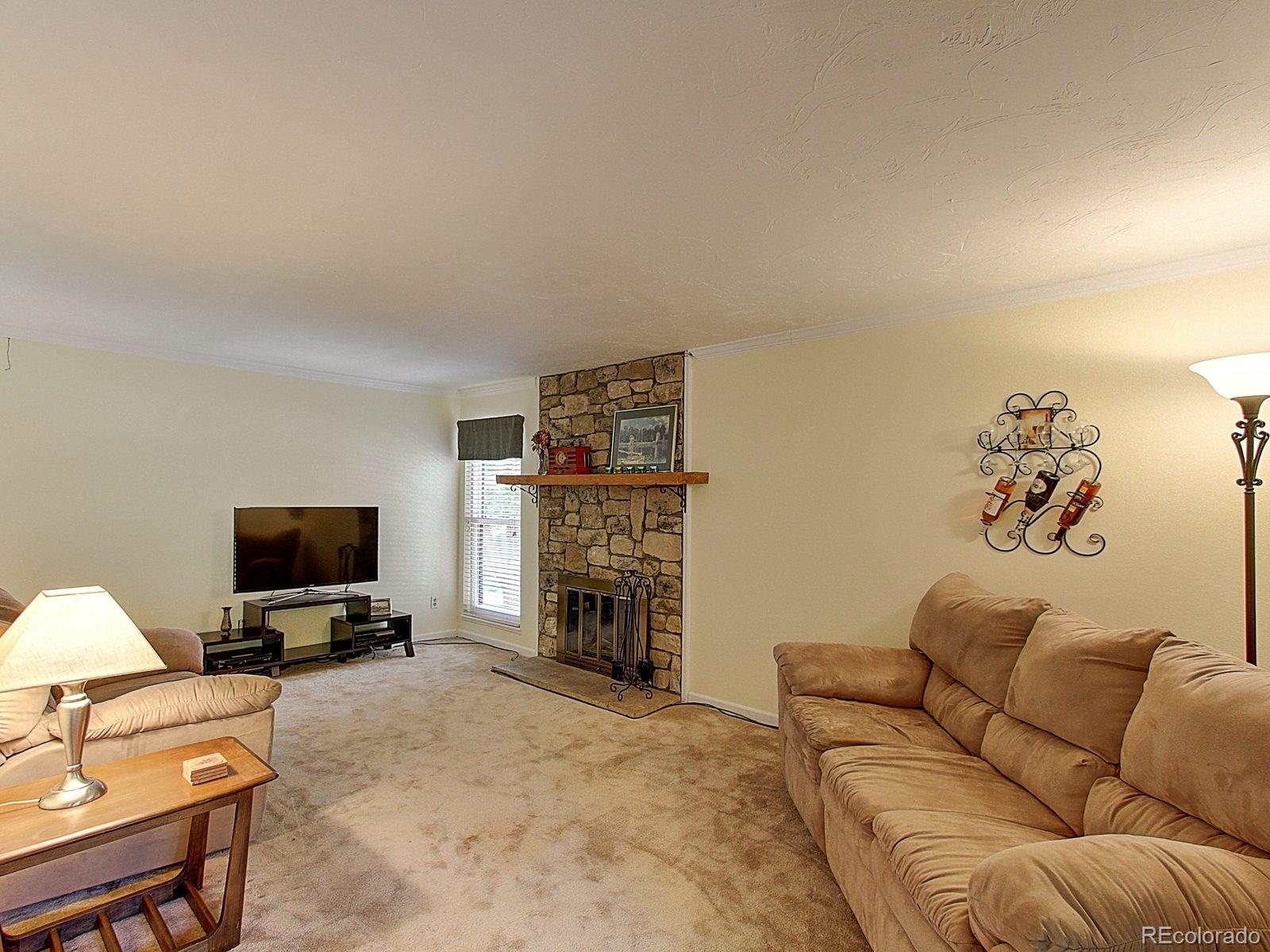 6410 South Dayton Street, Unit I08 Englewood, CO 80111 - Photo 5 of 32 a living room with furniture and a flat screen tv