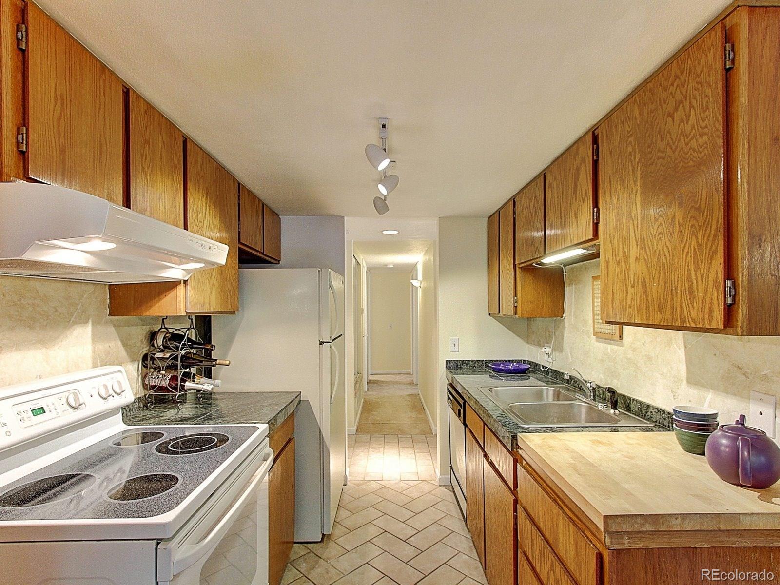 6410 South Dayton Street, Unit I08 Englewood, CO 80111 - Photo 9 of 32 a kitchen that has a sink and a stove