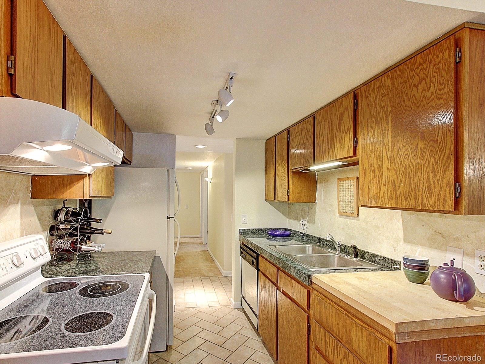 6410 South Dayton Street, Unit I08 Englewood, CO 80111 - Photo 10 of 32 a kitchen with a sink a stove and cabinets
