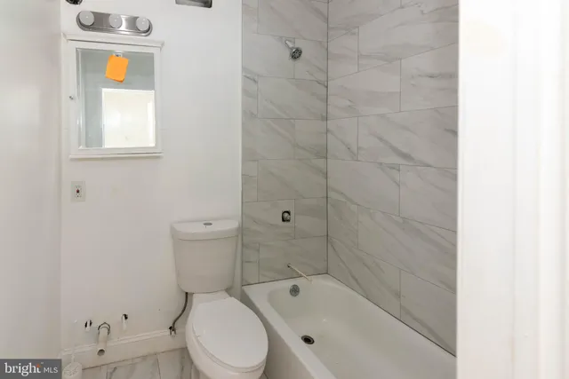 a white toilet sitting next to a bath tub