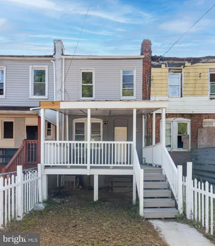 a view of a house with wooden deck and a yard
