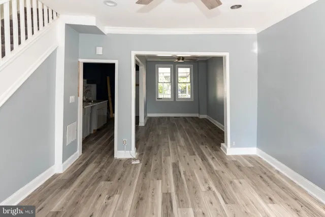a view of a room with wooden floor staircase and a kitchen