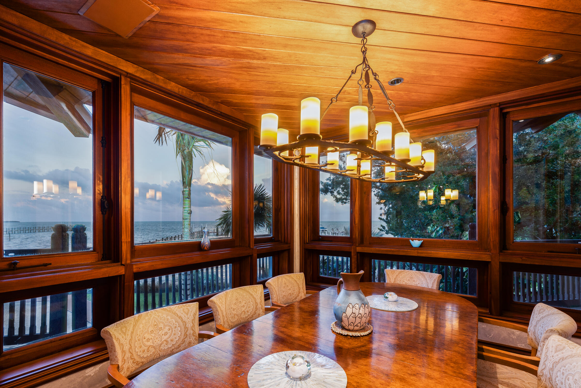 89301 Old State Road Tavernier, FL 33070 - Photo 22 of 99 a dining room with furniture large windows wooden floor and garden view