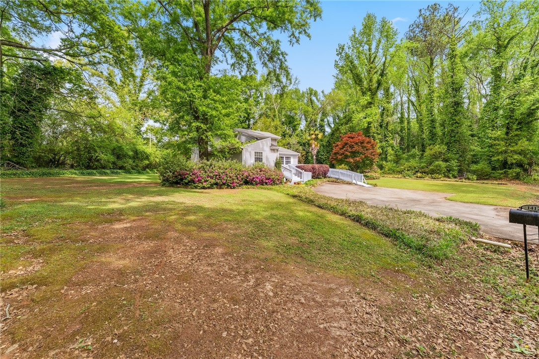 1412 Forest Lane Anderson, SC 29621 - Photo 2 of 31 A charming home nestled among lush greenery, offering a serene and expansive natural setting.