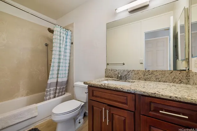 a bathroom with a granite countertop sink toilet and shower