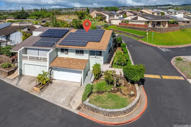 an aerial view of a house with a garden and lake view