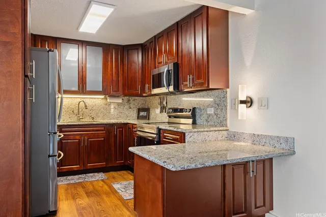 a kitchen with granite countertop wooden cabinets a sink and dishwasher